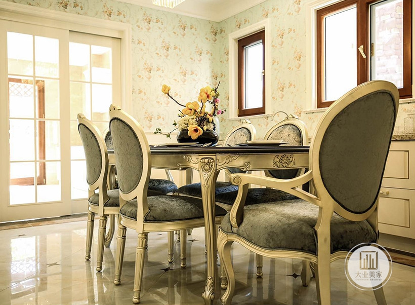 餐厅秉持典型的欧式古典风格搭配原则，餐桌和餐椅均为墨绿色，搭配金属雕花，配合扶手和椅腿的弧形曲度，显得优雅矜贵。